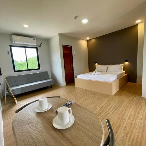a room with a bed and a table with two cups at The Grounds Hotel in San Jose del Monte