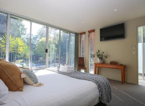 a bedroom with a large bed and a large window at The Glass Pinnacle in Bright