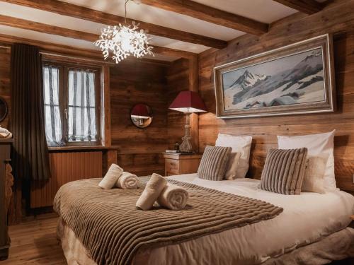 Un dormitorio con dos camas y una lámpara de araña. en Chalet montagnard intime avec hammam à Val d'Isère - FR-1-844-19, en Val dʼIsère