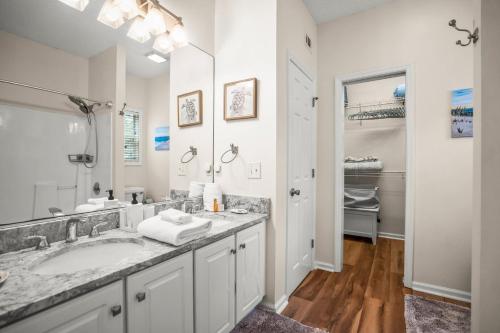 a white bathroom with a sink and a mirror at Beautifully appointed 3-Bed, 25-Bath Home, Great Location near Beach & Club in Fripp Island