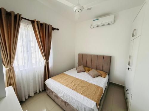 a small bedroom with a bed and a window at Airport S4 Apartment in Negombo