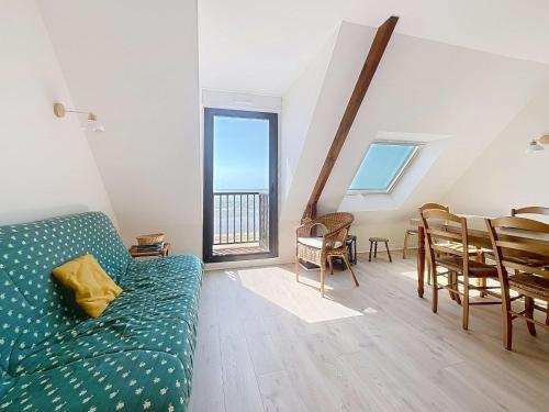 a living room with a green couch and a table at Appartement en bord de mer, 1 chambre, 4 couchages, parking privé - FR-1-361-570 in Jullouville-les-Pins