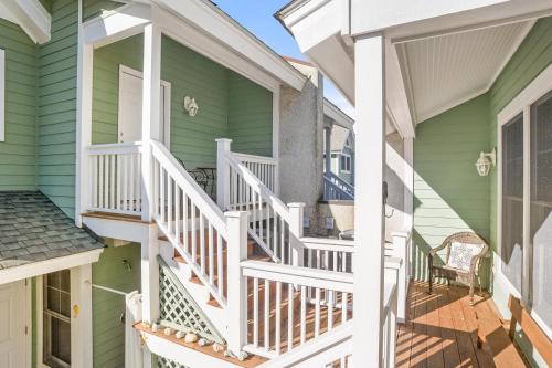 a front porch of a green house with white railings at Tasteful 2 Story 4 Bedroom, 4 Bath Home! New on Rental Program, Sleeps 12! in Fripp Island