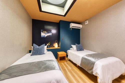 two beds in a room with a skylight at Liendepremie讃 貸切の宿 金刀比羅宮参道まで徒歩5分 敷地内駐車場5台 in Kotohira