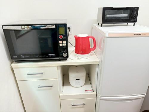 a microwave and a toaster oven on top of a refrigerator at 宿のきむら in Utsunomiya