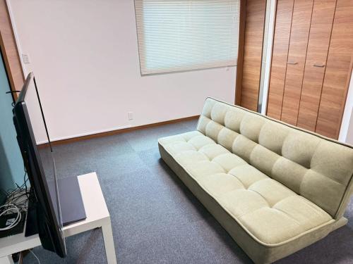 a living room with a couch and a tv at 宿のきむら in Utsunomiya