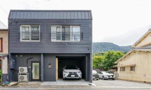 a black house with a car in the garage at Liendepremie讃 貸切の宿 金刀比羅宮参道まで徒歩5分 敷地内駐車場5台 in Kotohira