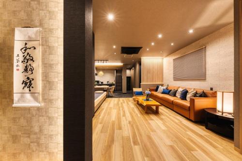 a living room with a couch and a kitchen at Liendepremie讃 貸切の宿 金刀比羅宮参道まで徒歩5分 敷地内駐車場5台 in Kotohira