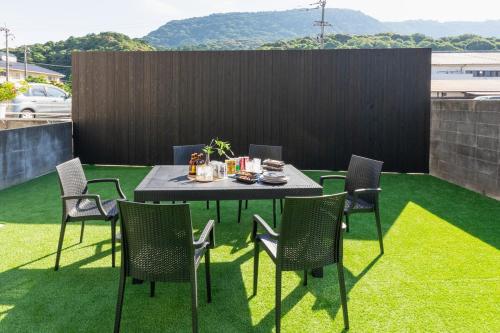 a table and chairs on a patio with grass at Liendepremie讃 貸切の宿 金刀比羅宮参道まで徒歩5分 敷地内駐車場5台 in Kotohira
