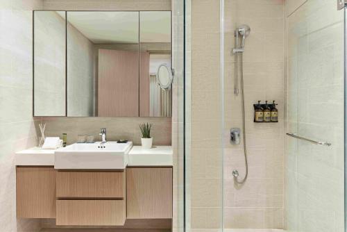 a bathroom with a sink and a shower with a mirror at Lanson Place Mall of Asia Manila in Manila