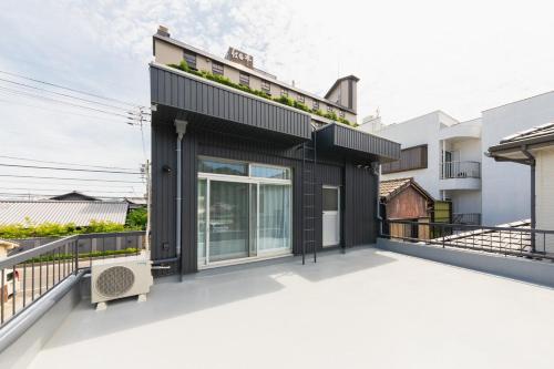 a black house with a white roof at Liendepremie讃 貸切の宿 金刀比羅宮参道まで徒歩5分 敷地内駐車場5台 in Kotohira