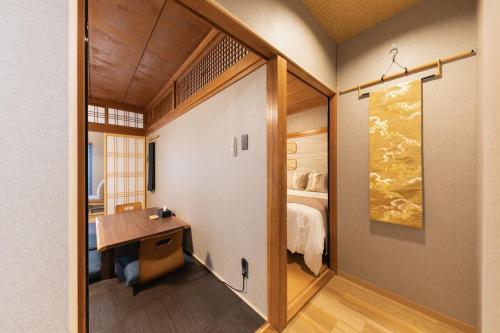 a room with a desk and a bedroom with a bed at Liendepremie讃 貸切の宿 金刀比羅宮参道まで徒歩5分 敷地内駐車場5台 in Kotohira
