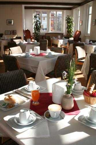 a dining room with white tables and chairs at Gasthof Albergo Kreuzwirt in Fiè