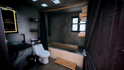 a bathroom with a toilet and a sink and a window at Cabaña misha in Chignahuapan
