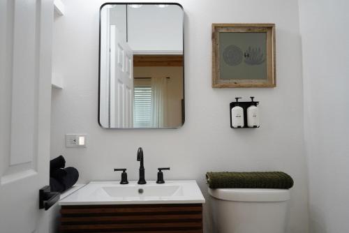 ein Badezimmer mit einem weißen Waschbecken und einem Spiegel in der Unterkunft Oak and Agave House - Downtown New Braunfels Retreat in New Braunfels