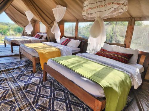 a bedroom with two beds in a tent at Kambu Mara Camp in Sekenani