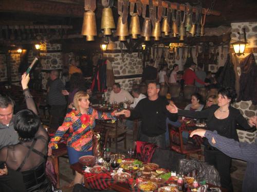 a group of people standing around a table in a restaurant at Family hotel Makedonska Kruchma in Dobrinishte
