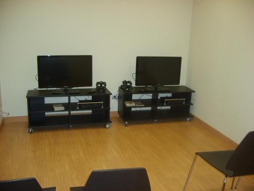two flat screen televisions on stands in a room at Aparthotel Bubal in El Pueyo de Jaca