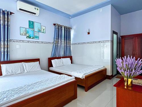 two beds in a bedroom with blue walls at Khách Sạn Toàn Uy - Đảo Phú Quý in Cu Lao Thu