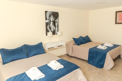 a room with two beds and a picture of a woman at Terminal Suites El Calafate in El Calafate