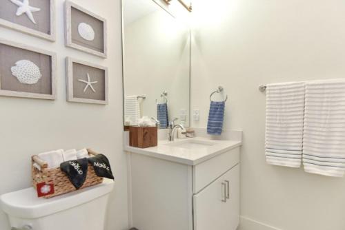 a white bathroom with a sink and a toilet at The White House on Flagler Beach - Unit 23 in Flagler Beach