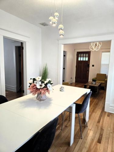 a white dining room table with a vase of flowers on it at Pinkston Gardens in Saint Paul