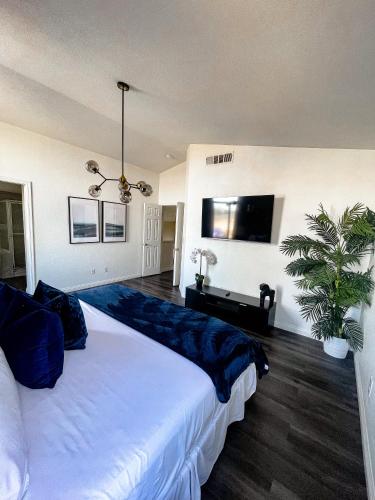 a bedroom with a large white bed and a potted plant at VEGAS GEM 4BDR KING BED Wifi GARAGE PRKNG in Las Vegas