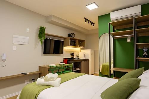 a green and white bedroom with a large bed at Nik Perdizes in Sao Paulo