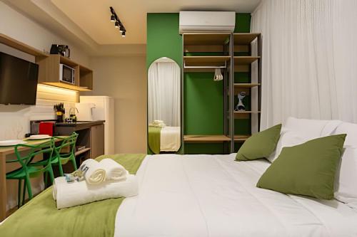 a bedroom with a white bed and a green wall at Nik Perdizes in Sao Paulo