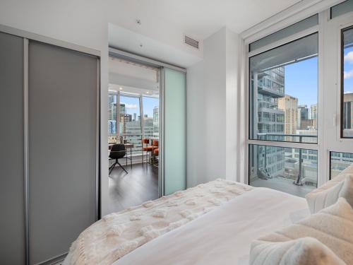 Un dormitorio con una cama y una ventana grande. en Nobu Suites - Toronto's Entertainment District, en Toronto