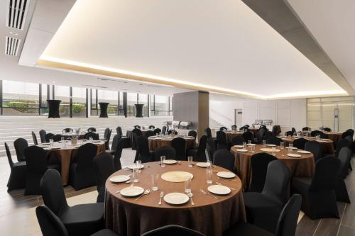 a room with tables and chairs and a room with windows at FOX Hotel Glenmarie Shah Alam in Shah Alam