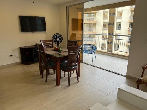 a dining room with a table and chairs and a balcony at Apartamento de descanso y relajación en Villeta in Villeta
