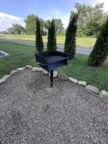 a black picnic table sitting on the gravel in a park at The Roscoe Boutique Motel in Coshocton