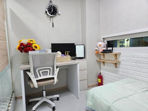 a bedroom with a desk with a computer and a bed at Halla Livingtel in Goyang