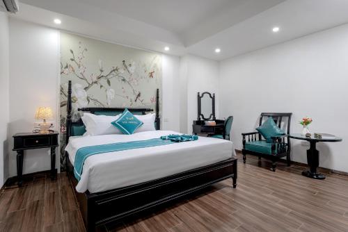 a bedroom with a large bed and a table and chairs at Vũ Hotel in Ninh Binh