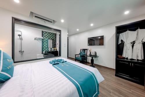 a bedroom with a large white bed and a bathroom at Vũ Hotel in Ninh Binh