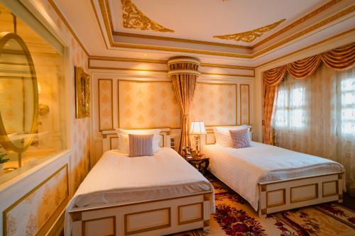 a bedroom with two beds and a ceiling at Dalat Palace Heritage Hotel in Da Lat