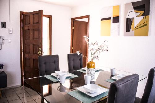 a dining room with a glass table and chairs at Amplio Departamento 3 Centro Historico - Wide Apartment 3 Downtown in San Luis Potosí