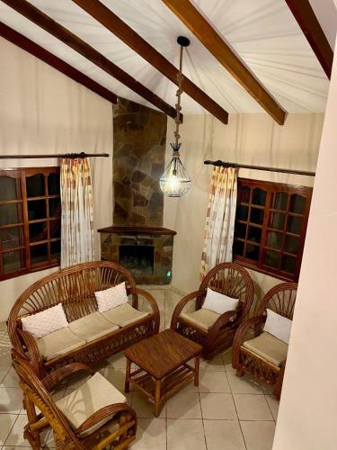 a living room with chairs and a fireplace at Cabaña Las Retamas in Samaipata