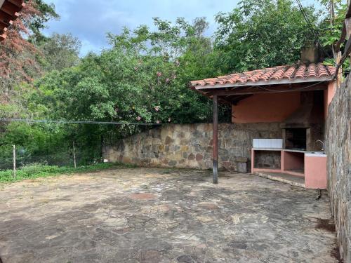 a building with a stone wall next to a building at Cabaña Las Retamas in Samaipata