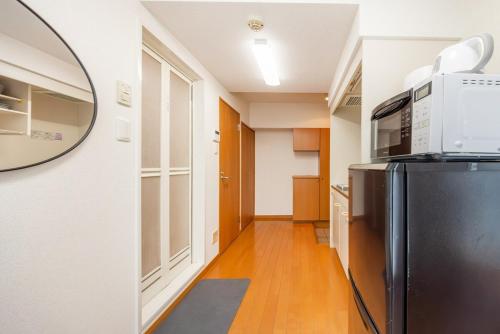 a kitchen with a black refrigerator and a microwave at JR Kamata Station is a 3-minute walk, Shinagawa is 7 minutes by train, and Keikyu Kamata Station has direct access to Haneda Airport, Tokyo, Shinagawa, Yokohama, and Ueno in Tokyo