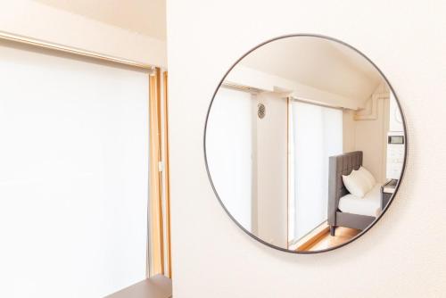 a mirror hanging on a wall next to a room at JR Kamata Station is a 3-minute walk, Shinagawa is 7 minutes by train, and Keikyu Kamata Station has direct access to Haneda Airport, Tokyo, Shinagawa, Yokohama, and Ueno in Tokyo