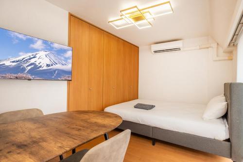 a small room with a bed and a table at JR Kamata Station is a 3-minute walk, Shinagawa is 7 minutes by train, and Keikyu Kamata Station has direct access to Haneda Airport, Tokyo, Shinagawa, Yokohama, and Ueno in Tokyo