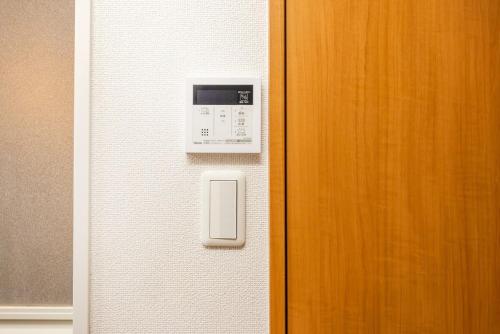 a microwave on a wall next to a door at JR Kamata Station is a 3-minute walk, Shinagawa is 7 minutes by train, and Keikyu Kamata Station has direct access to Haneda Airport, Tokyo, Shinagawa, Yokohama, and Ueno in Tokyo
