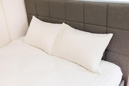 a white pillow sitting on top of a bed at JR Kamata Station is a 3-minute walk, Shinagawa is 7 minutes by train, and Keikyu Kamata Station has direct access to Haneda Airport, Tokyo, Shinagawa, Yokohama, and Ueno in Tokyo