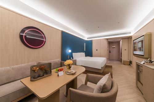 Postel nebo postele na pokoji v ubytování Guangzhou Olympic Sports Centre Financial City Crystal Orange Hotel