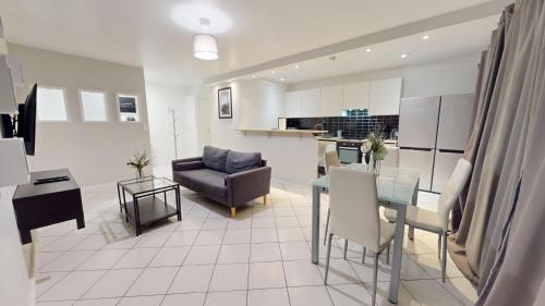 Il comprend un salon et une cuisine avec une table et un canapé. dans l'établissement Grand appartement lumineux, au Havre