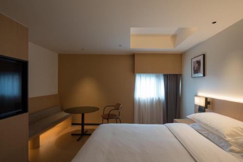 a hotel room with a bed and a table and a tv at SFEEL设计师酒店 Designer Hotel成都春熙路IFS国金中心店 in Chengdu