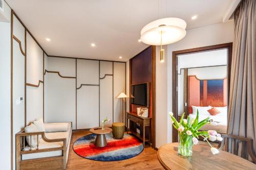 a living room with a table and a dining room at Golden Sands Bayfront Mũi Né in Mui Ne