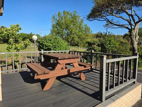una mesa de picnic en una terraza con una valla en Jeju Albam Oreum House Pension, en Jeju